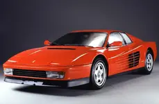 4ZEjK4ehbxzxJe7SNqit4J-2f19fe55ff53128387ded42811e87b30-ferrari-testarossa-front-1100.webp