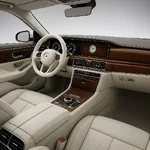 Interior of a modern S-class with white leather and lots of wood.webp